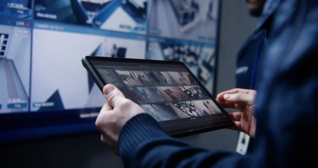 Security monitoring services operator monitoring CCTV cameras on a tablet in a police surveillance center