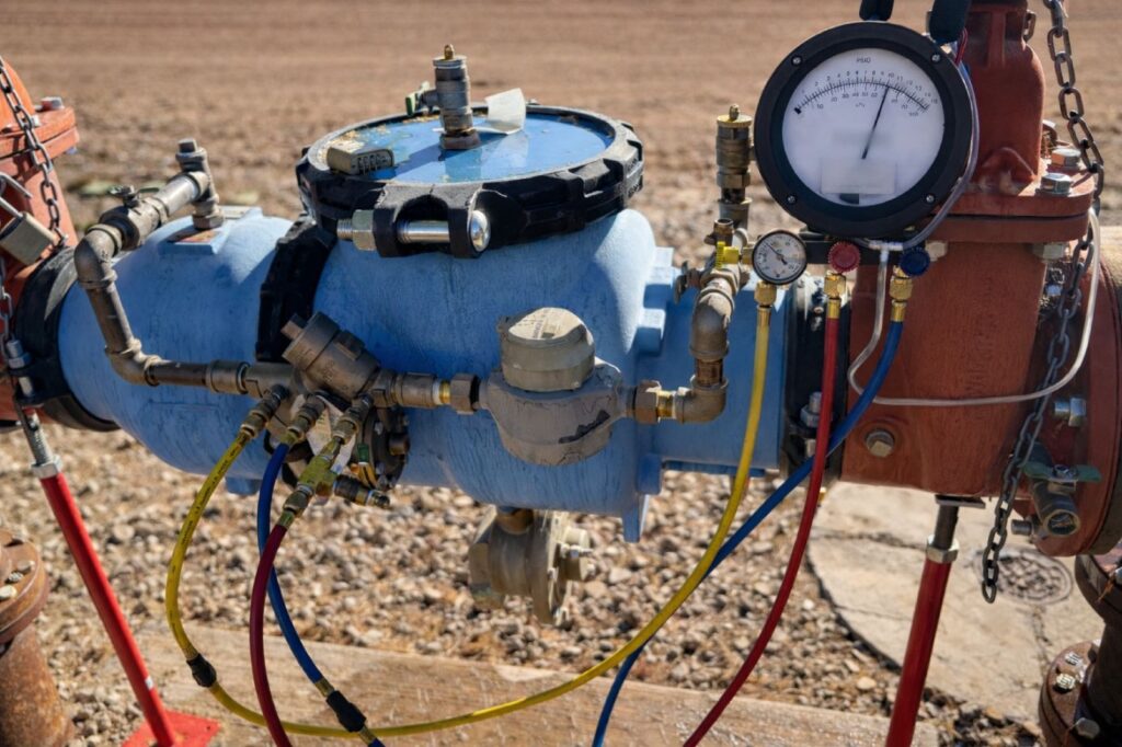 A backflow preventer assembly with pressure gauges and test hoses connected during field testing.