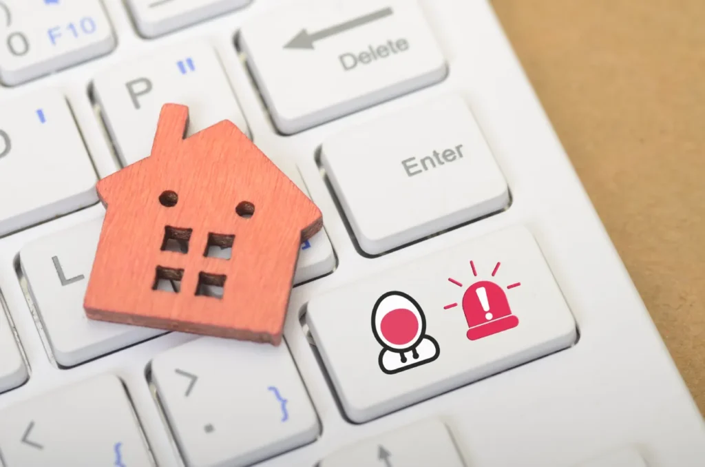 Miniature house on a keyboard with alarm icons representing central burglar alarm monitoring for homes