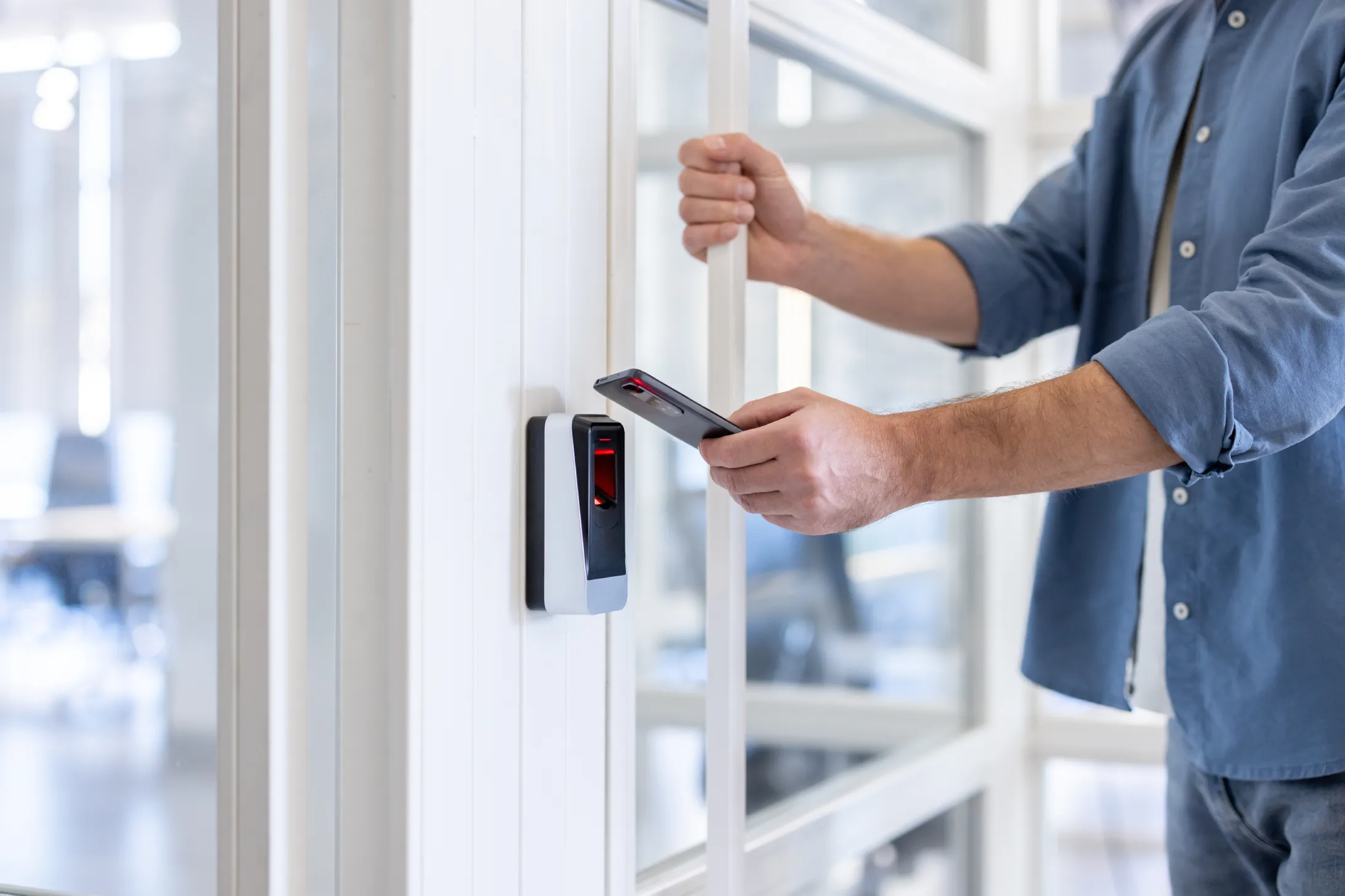 Man using a smartphone as a mobile credential for commercial access control systems